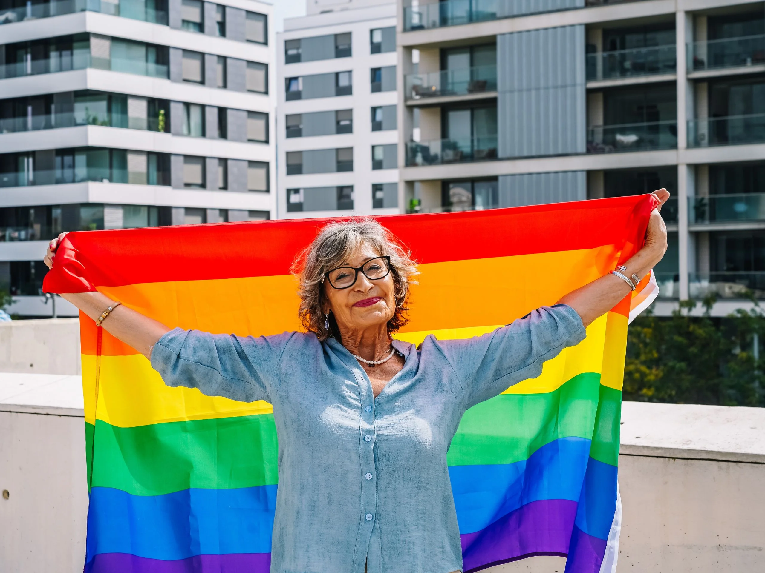 Mujer mayor sosteniendo la bandera LGTBIQ+