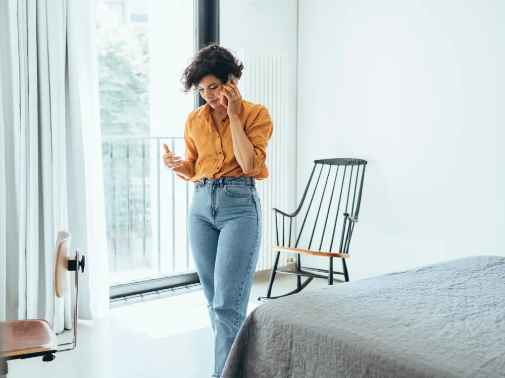 Mujer hablando por teléfono en dormitorio
