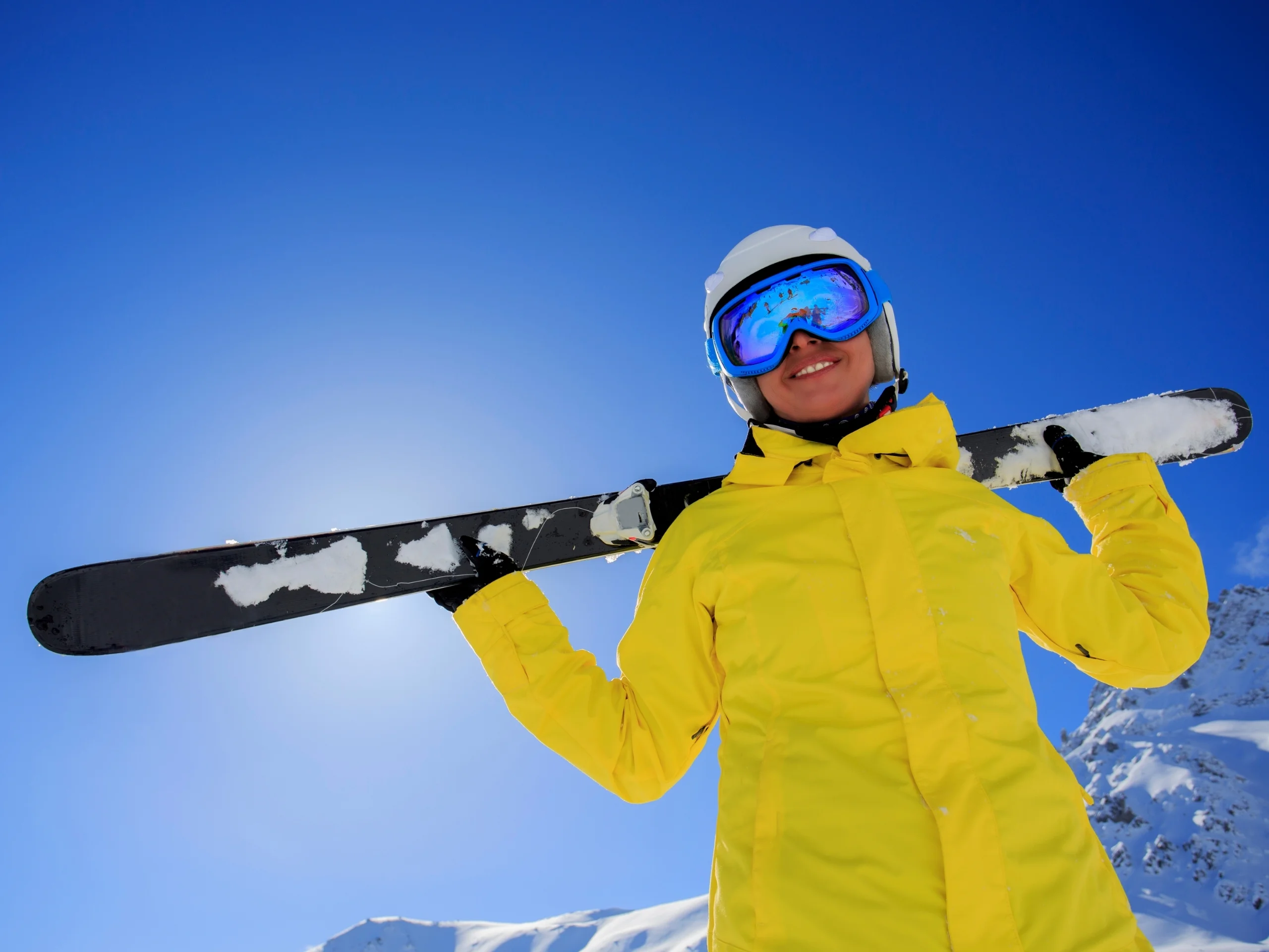 Mujer joven sujetando un esquí en los hombros