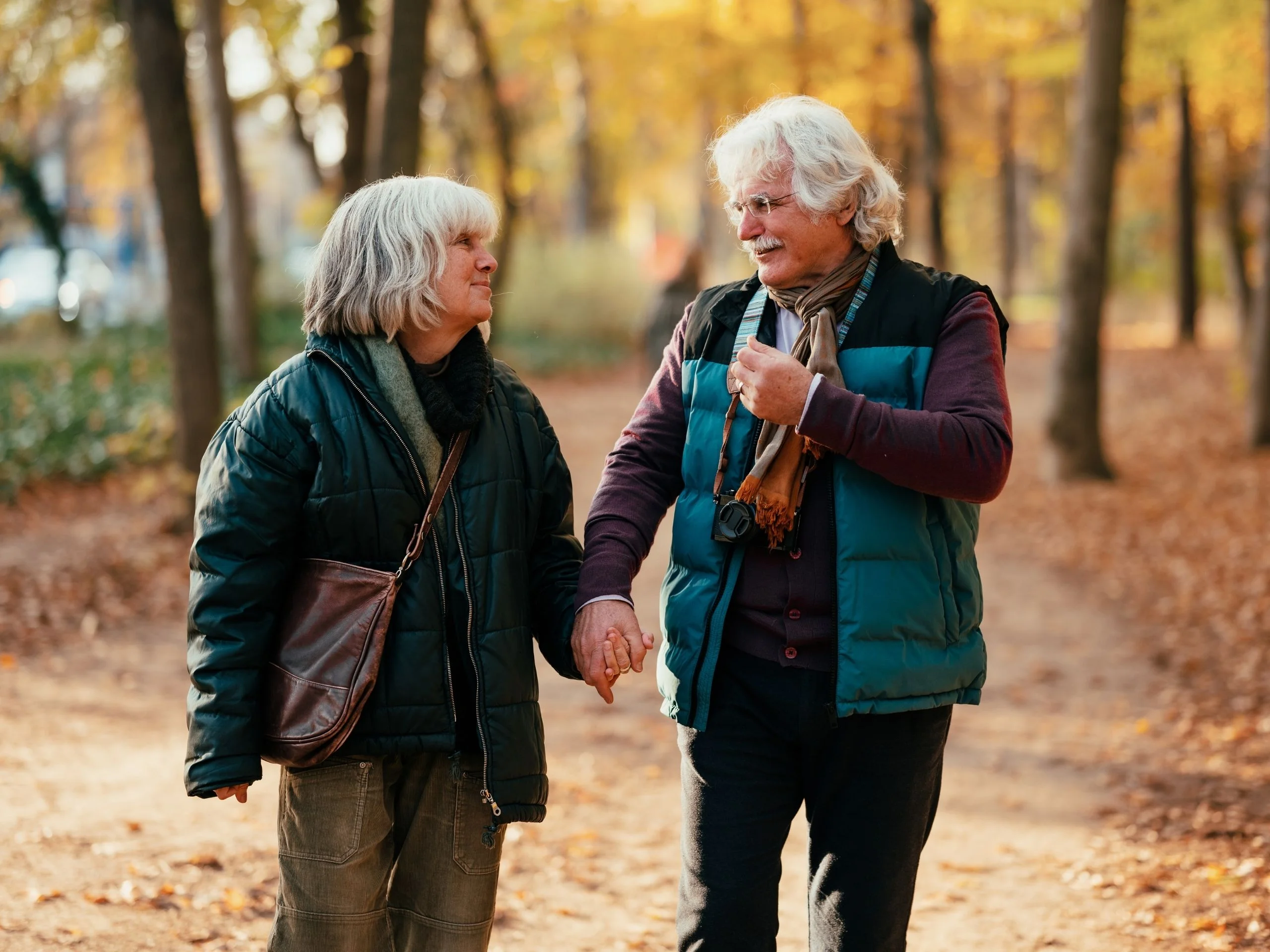 Pareja de personas de la tercera edad paseando de la mano