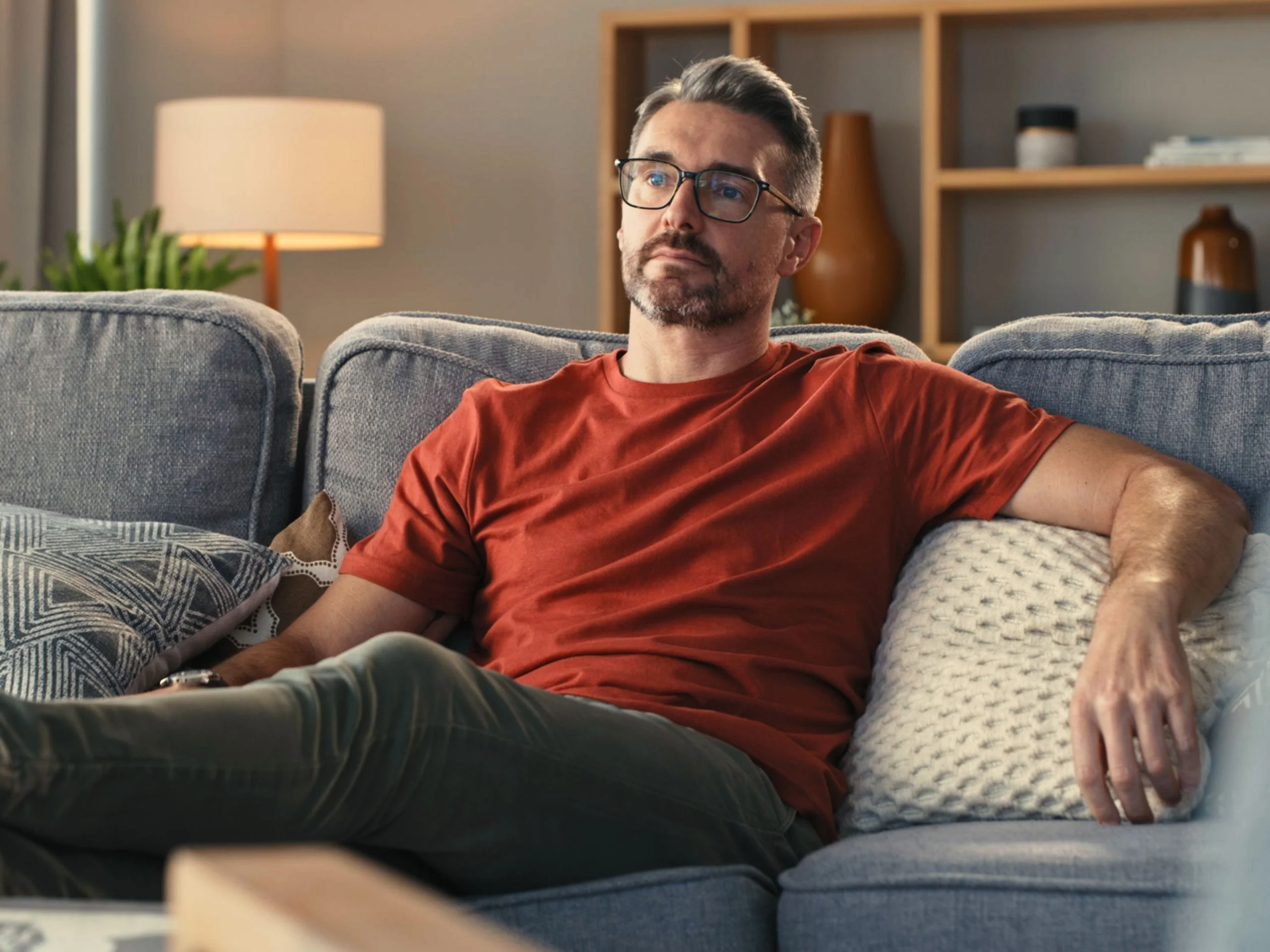 Hombre maduro estirado en el sofá de su casa
