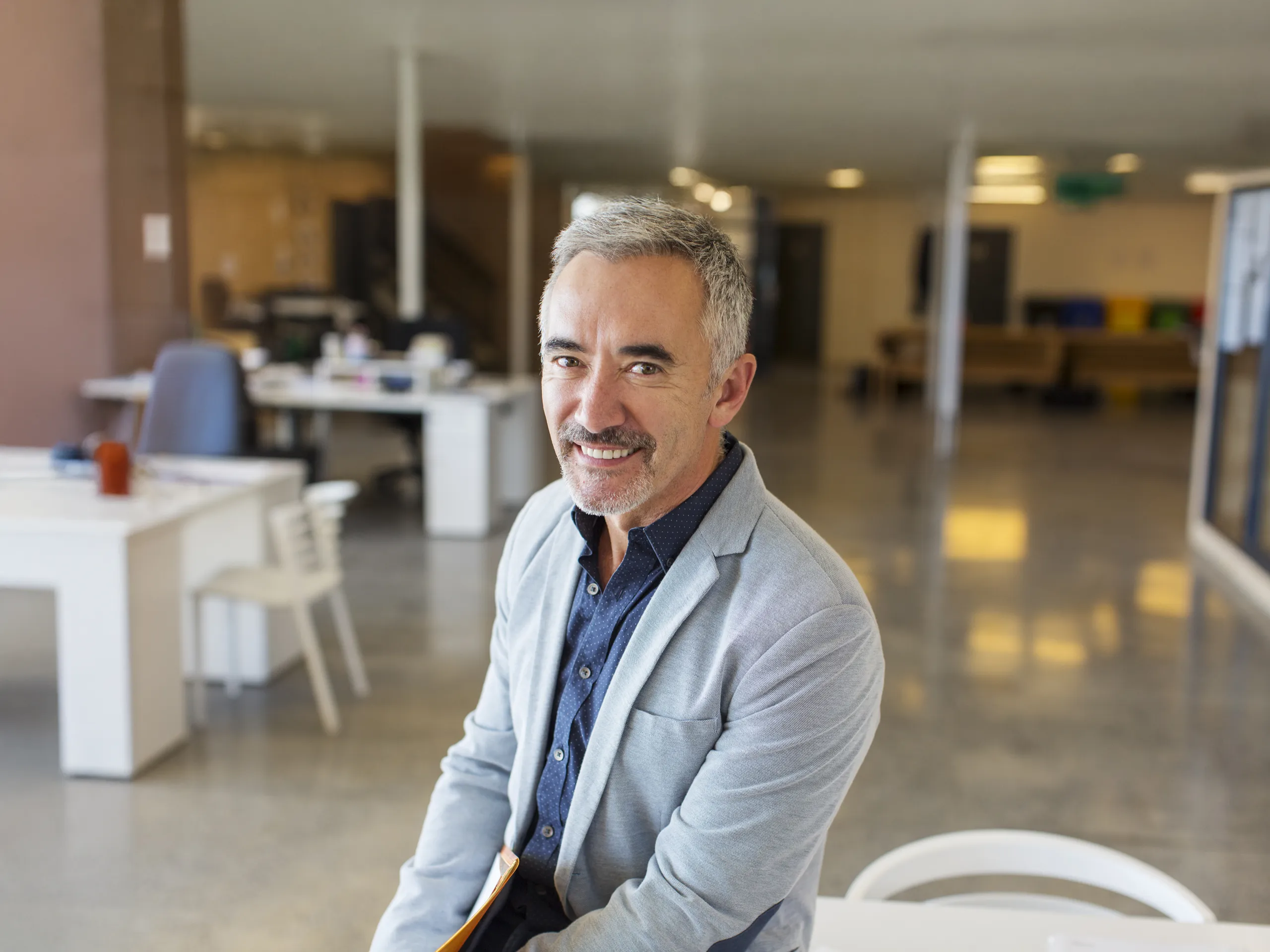 Hombre de negocios sonriente en una oficina abierta y luminosa.