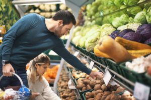 Hombre comprando en la sección de verduras y hortalizas de un supermercado