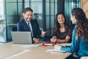 Notario con traje atendiendo a dos clientas