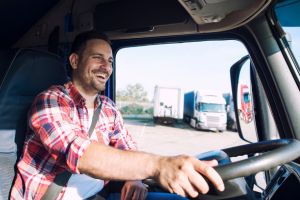 Hombre blanco al volante de un camión sonriente